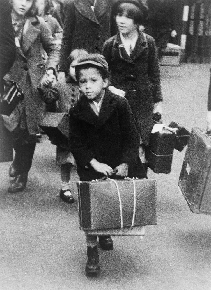 Evakuiert Die Aufnahme zeigt einen kleinen Jungen mit seinem Gepäck, der zusammen mit anderen Evakuierten am 5. Juli 1940 von London aus in eine ländliche Region reist.